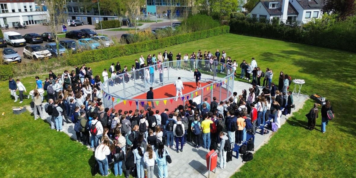 Luchtfoto van het schoolplein van CSW Walcheren met honderden leerlingen rond de pannakooi.