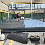 Aanbrengen van de circulaire sportvloer op het dakterras